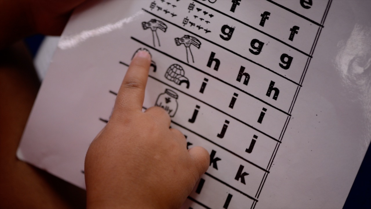 Child points at letter sound picture.