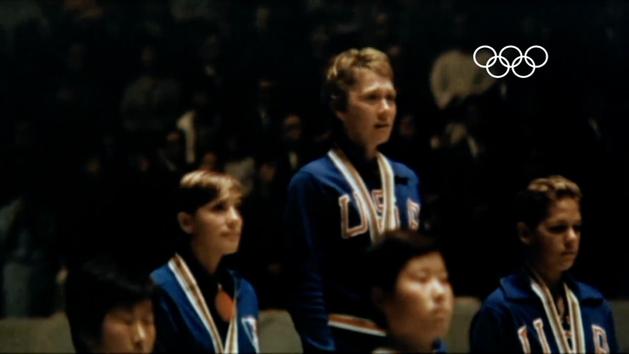 LBSU Olympian standing on the top of the medal podium.