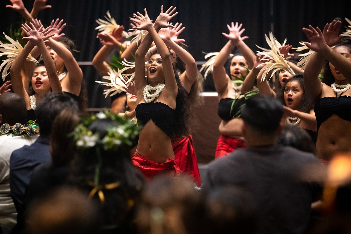 Grads raise their hands at the 2022 Pacific Islander Cultura
