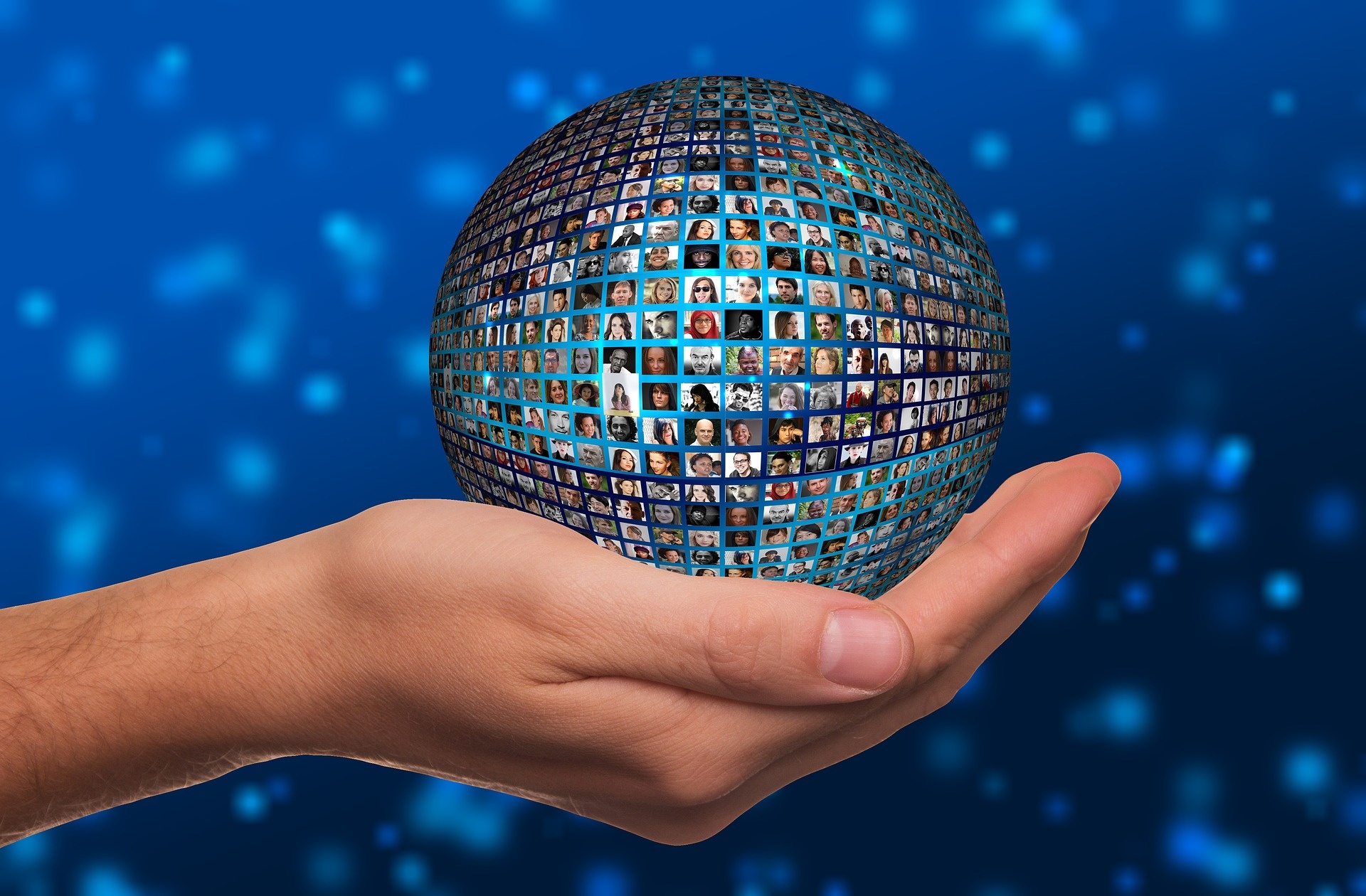 pexels-hand-gd97452a3b_1920.jpg hand holding a globe with pictures of people