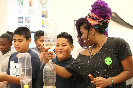 student-teacher demonstrating fluid dynamics to an excited k