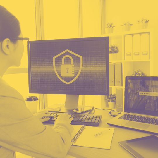 security_training_mustard_transparency75.png Women on a computer with screen showing a padlock