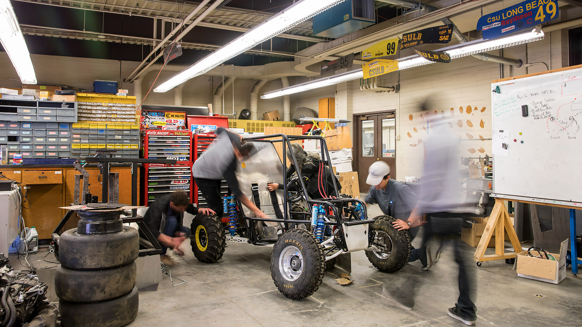 Engineering students work on baja car.