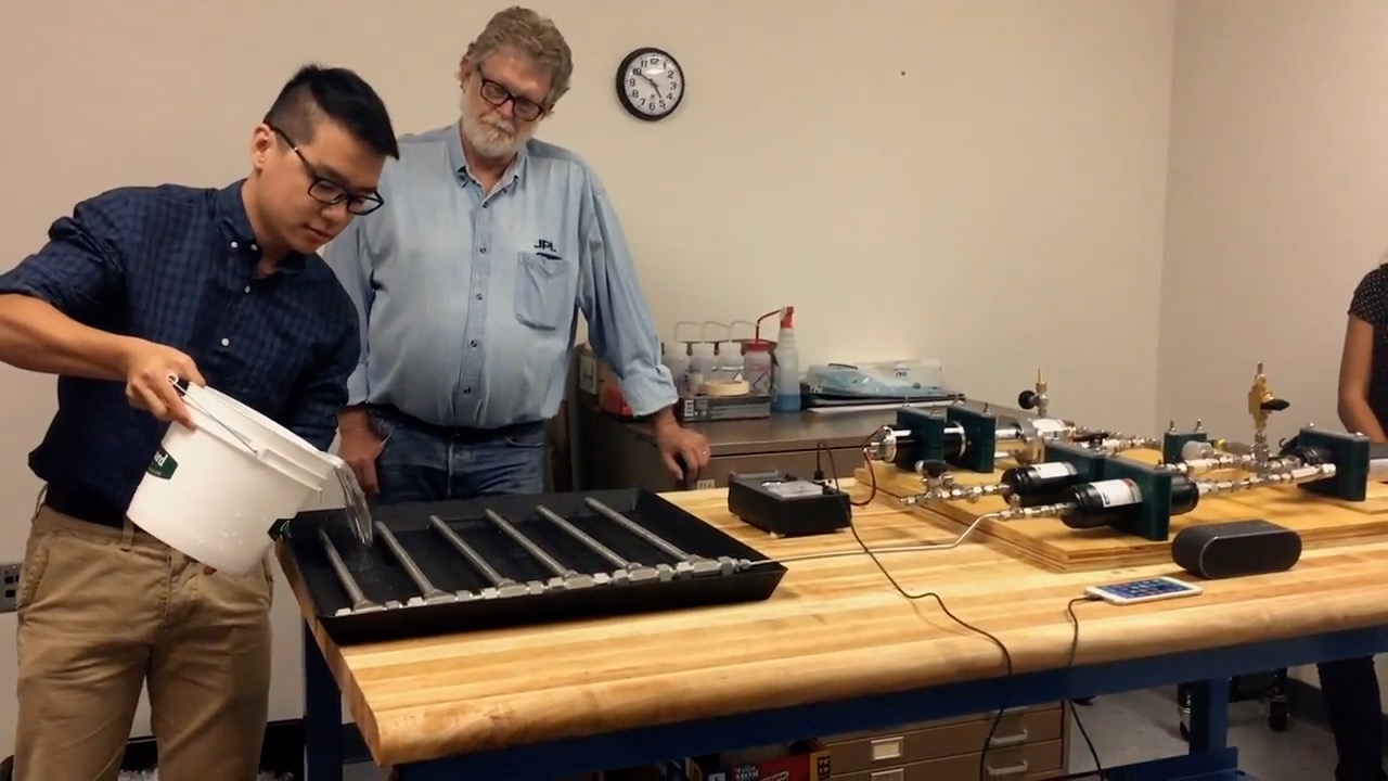 Phuong Tran pours water on a thermal recharging battery.