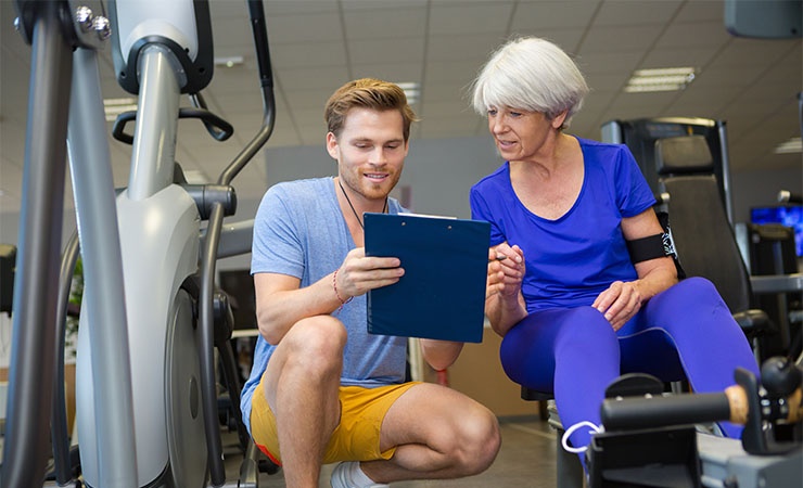 trainer_with_clipboard.jpg Clinical trainer with clipboard helping elderly woman
