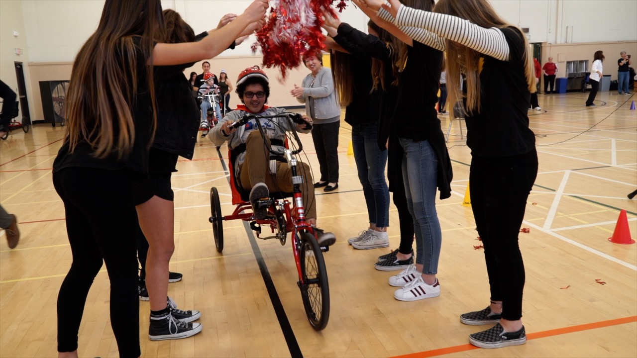 Special needs child rides a custom adaptive tricycle.