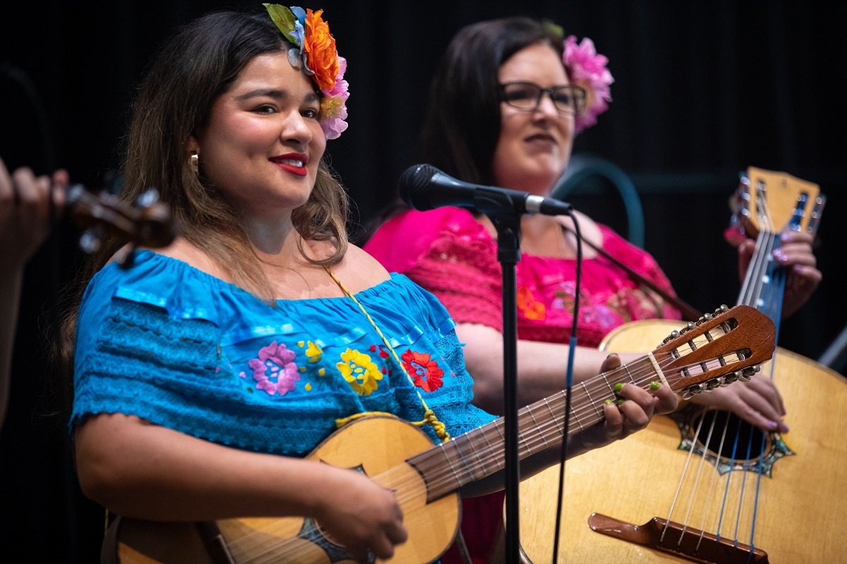undocumented-01_rs.jpg A woman plays a stringed instrument at the 2022 Undocumented