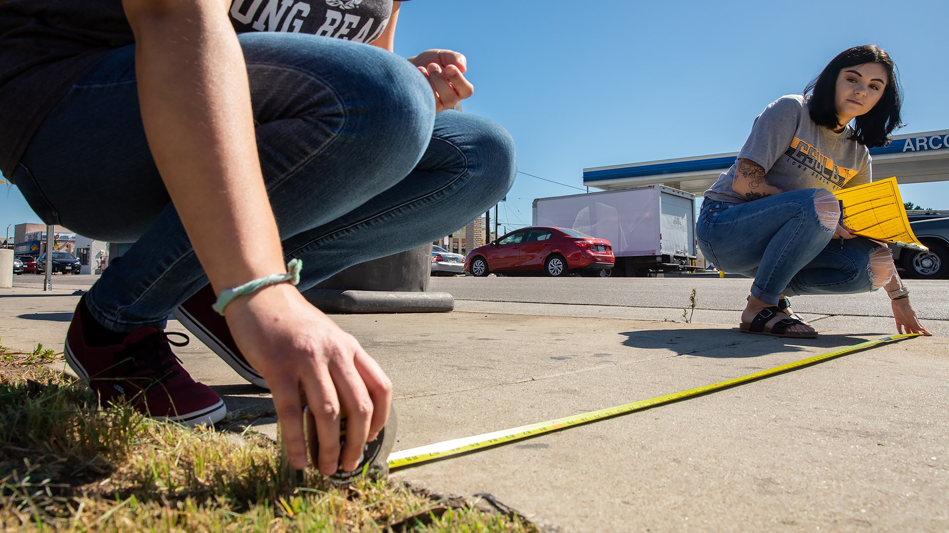 students measuring sidewalk