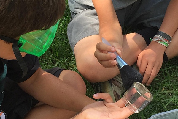 ysc_topic_csi_long_beach.jpg children brushing a glass container for fingerprints
