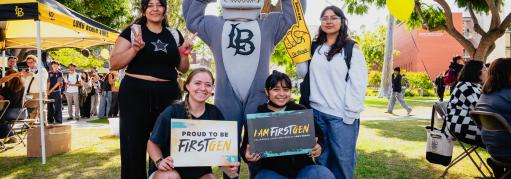 Group of four students celebrating FirstGen celebration with Elbee the shark.