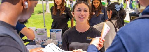 Students receiving information at an on-campus boothing event.