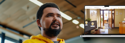 person in a yellow hoodie in a classroom with a computer with a simulation game on it
