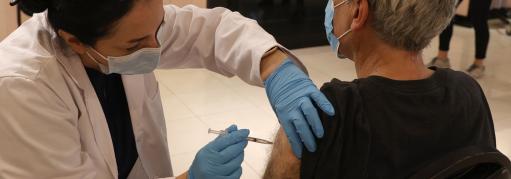 Healthcare professional injects the COVID-19 vaccine into a patient