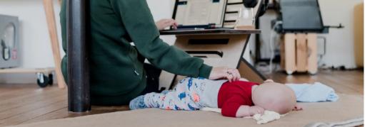 Mother working from home with a baby on the floor