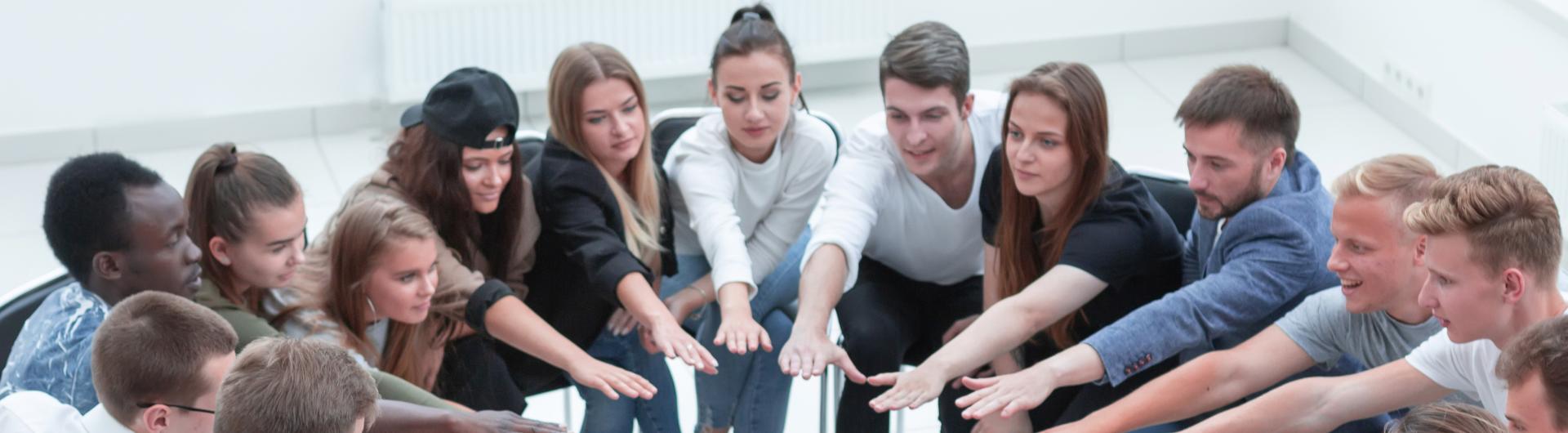 Students In A circle with hands extended together team work