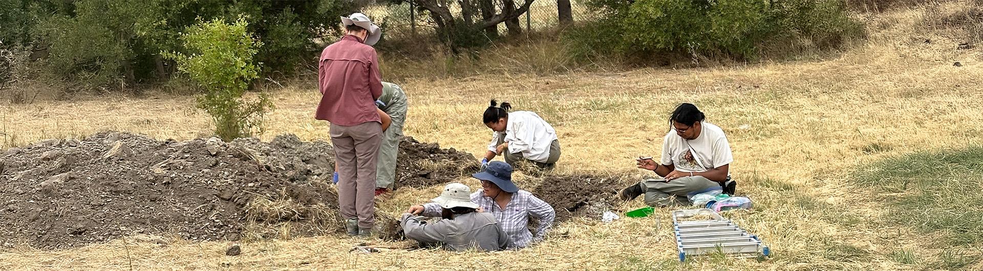 researchers examining contents of trench dug into the ground