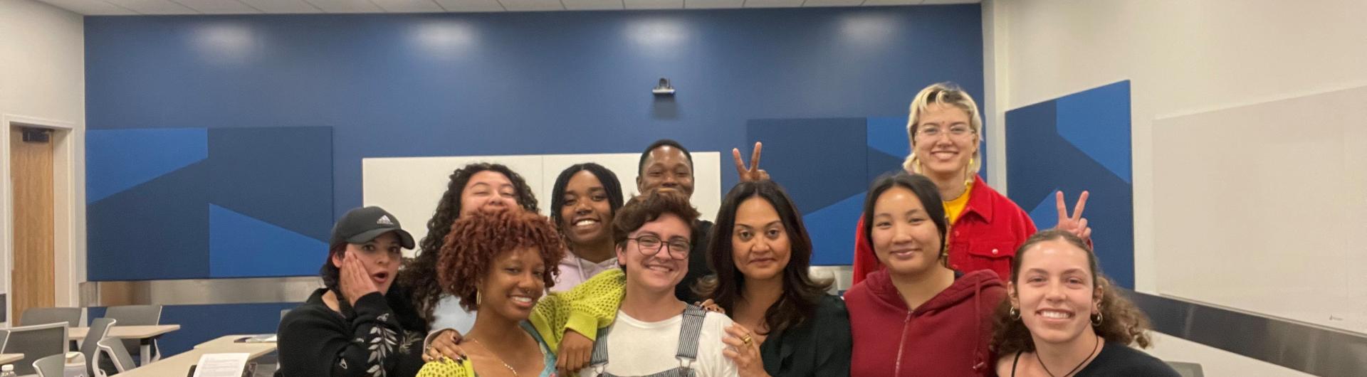 group of people smiling in front of a blue wall