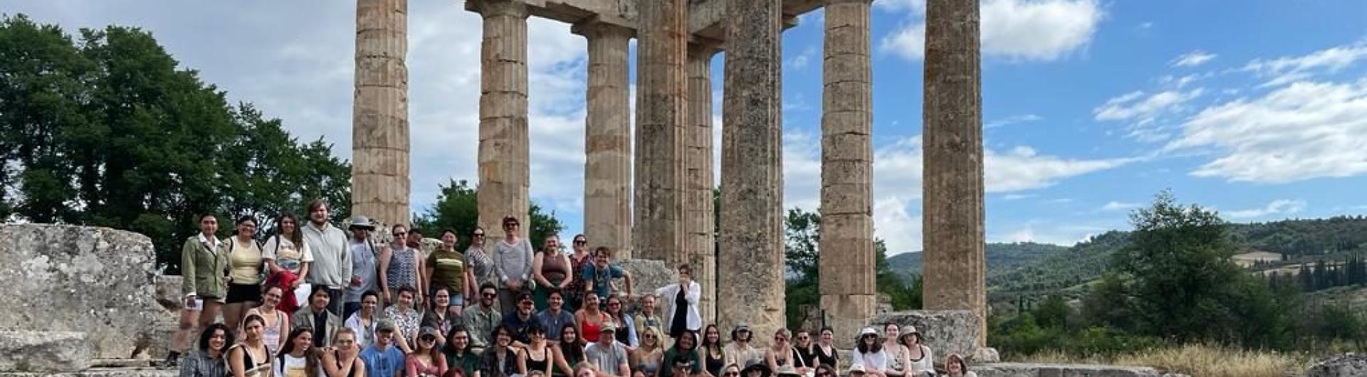 archaeologists posing before an ancient ruin