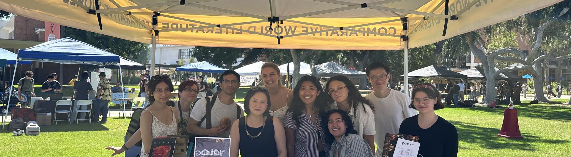 students under an awning at a table