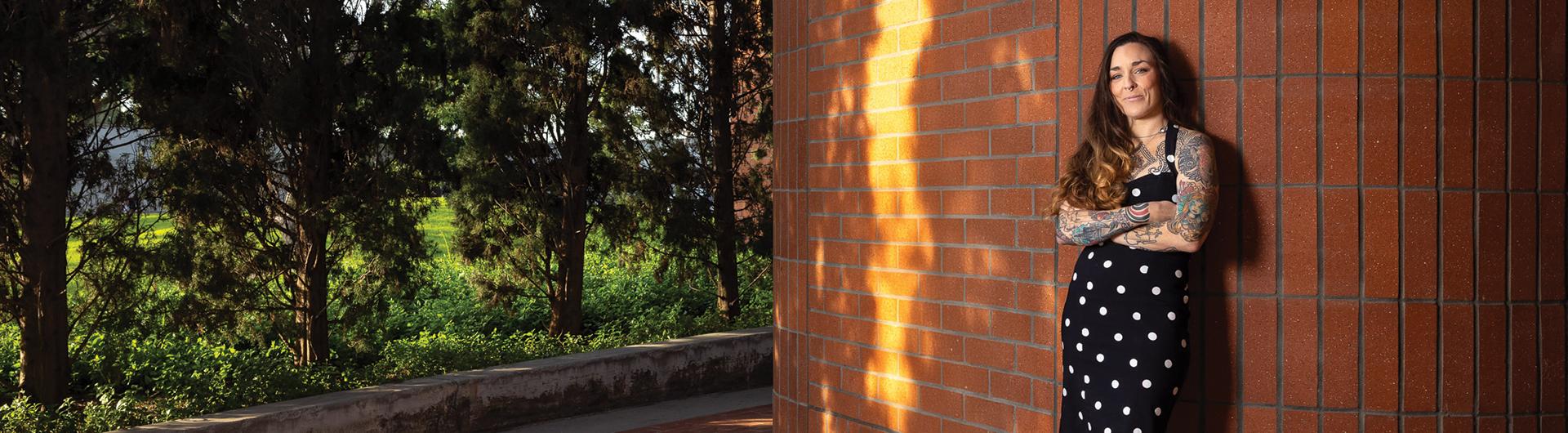 Taryn Williams stands against a brick wall at the College of Business