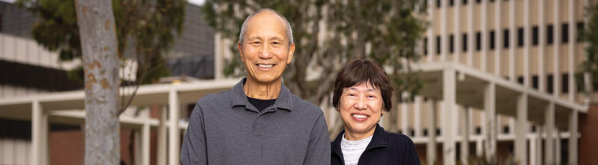 Two people stand in front of a building