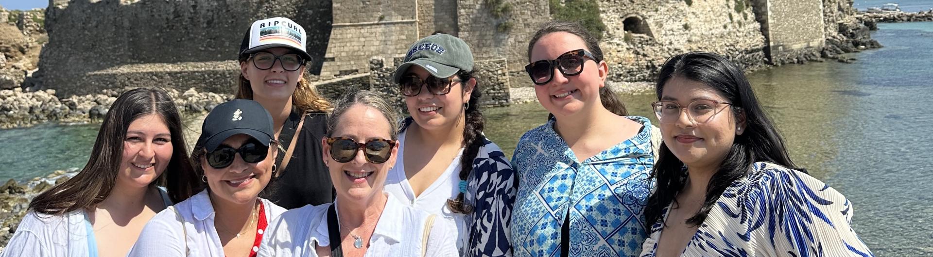 people in front of medieval castle by water