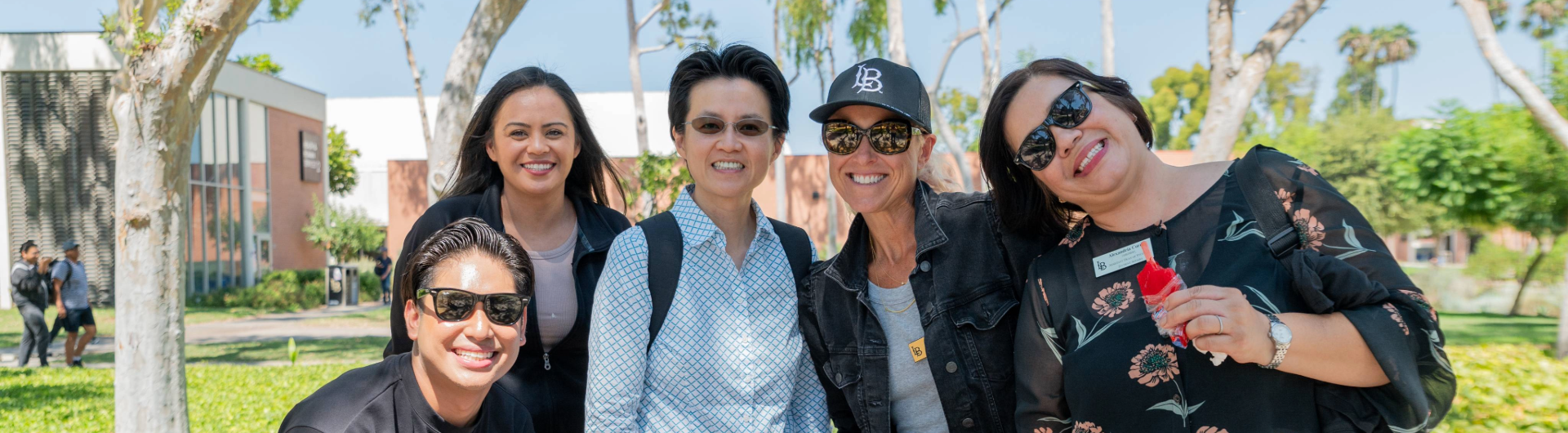 Five people standing together smiling