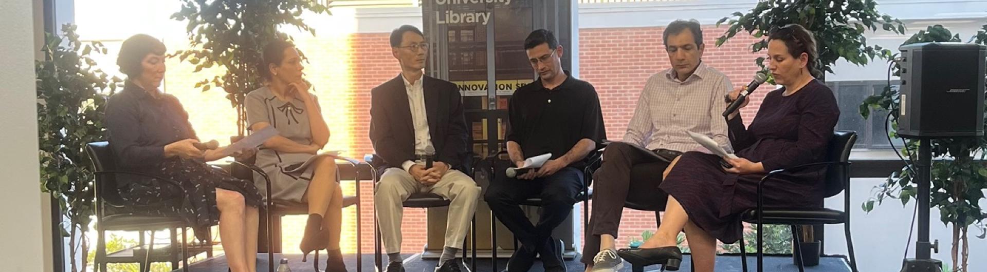 A group of panelists forming a half circle and holding microphones