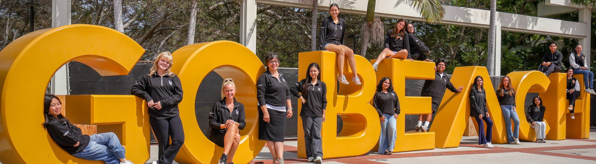 students standing in front of a sign that reads Go Beach