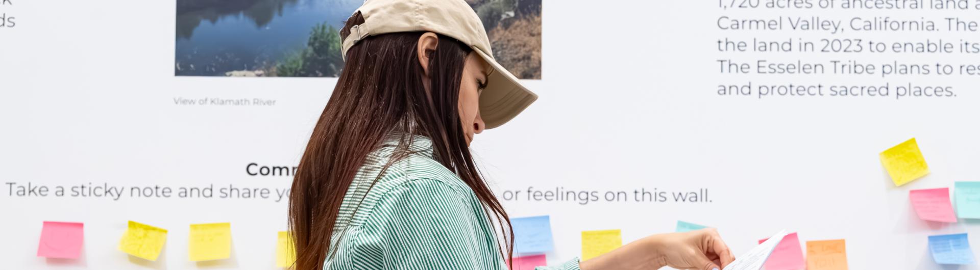 Person standing and flipping through papers in hand