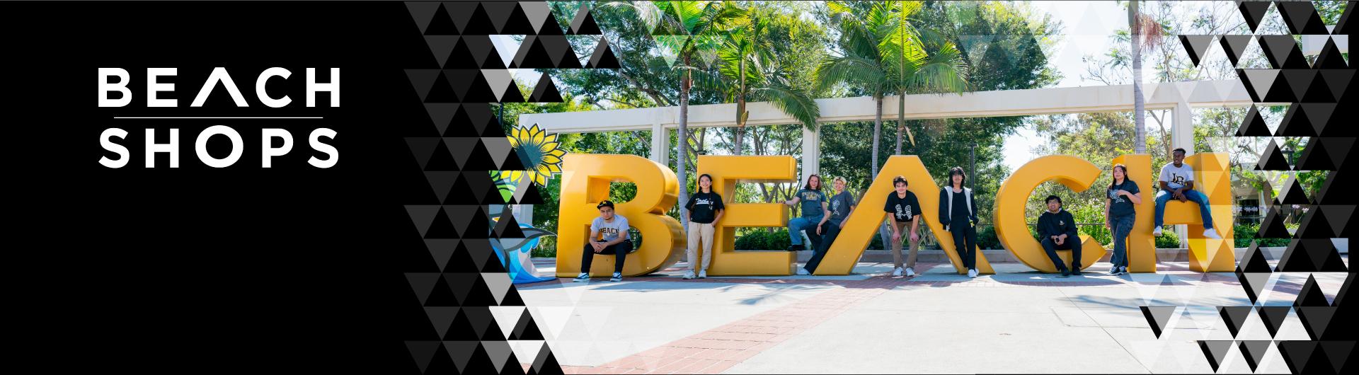 The Go Beach sign on CSULB campus with students dispersed throughout smiling at the camera.