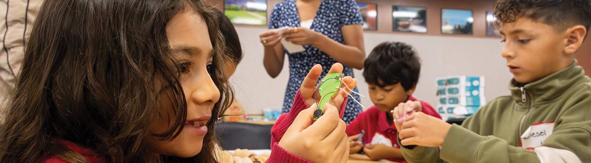 Children from Handy Elementary building a robotic bug
