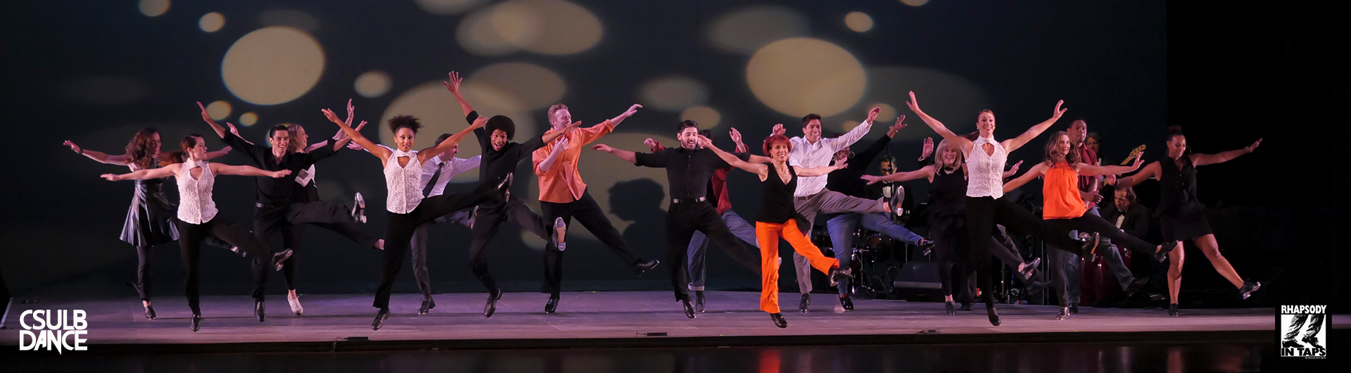 A stage full of energetic tap dancers and musicians. 