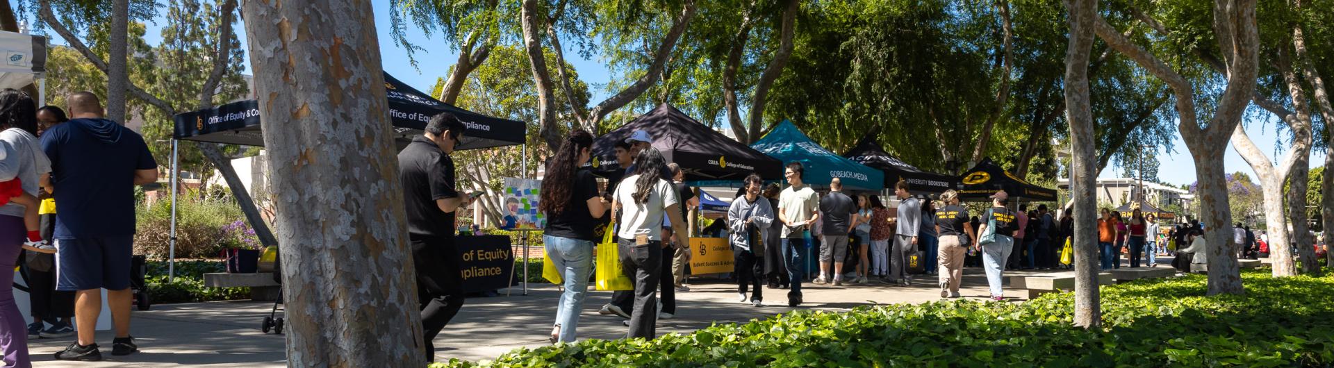 Students walking past tables at Day at The Beach.