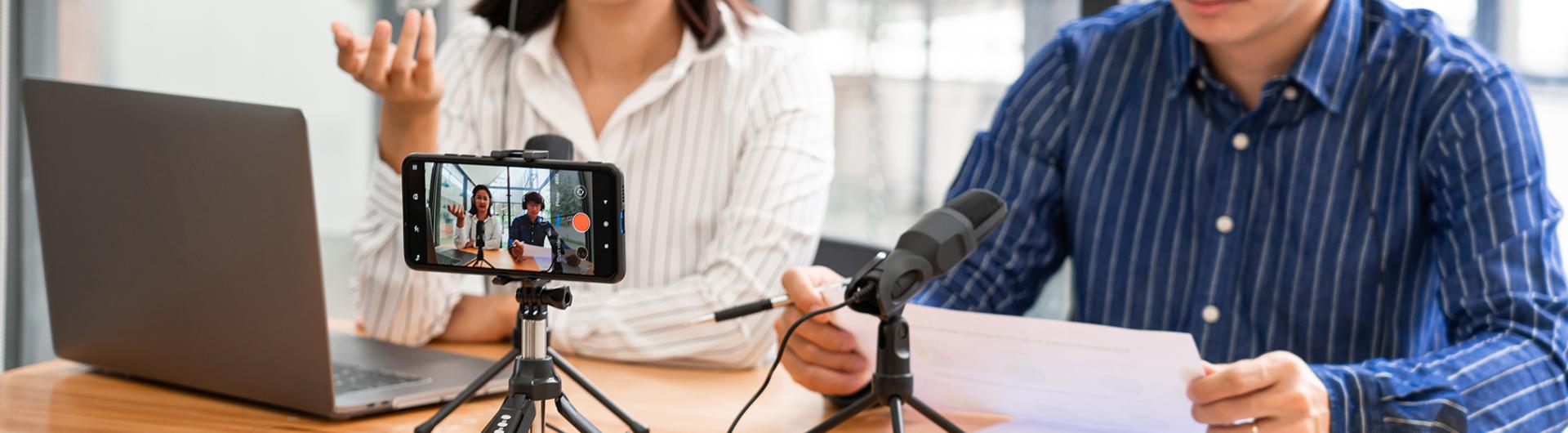 faculty recording video on laptop with mobile phone