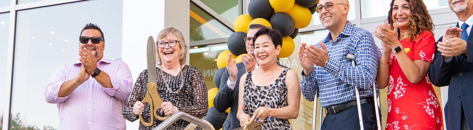 Anna Ngai, Jane Close Conoley and others cut ribbon at Alumni Center