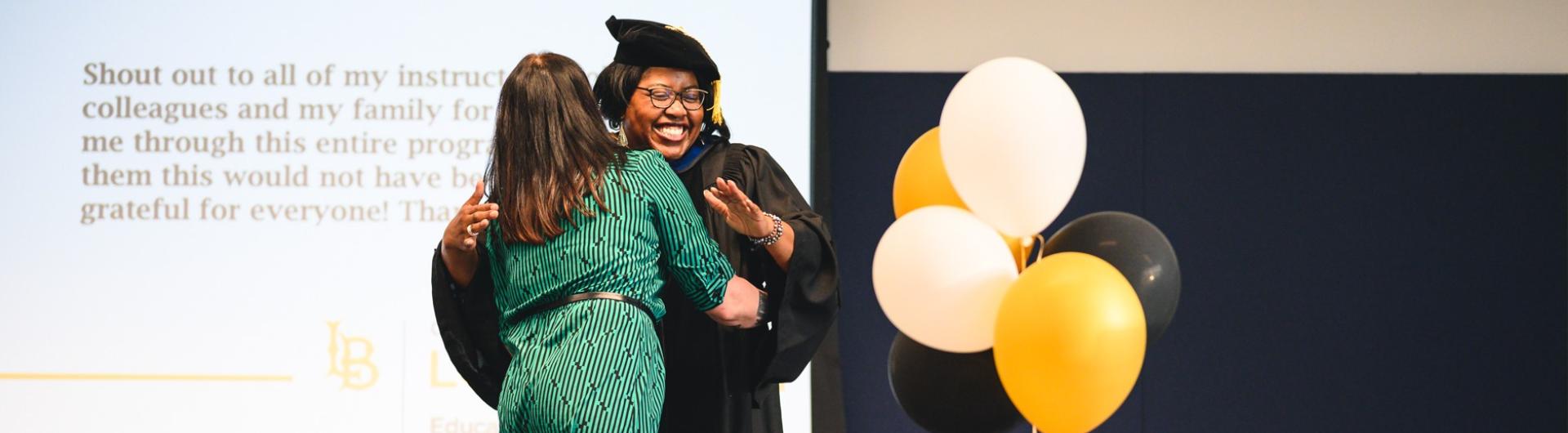 Graduate gets a hug at CSULB Educational Administration Graduation