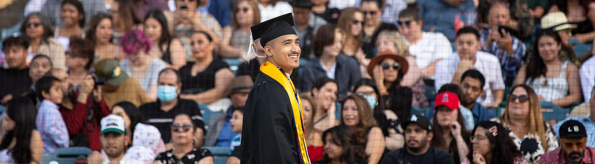 Graduate walks past crowd at Commencement