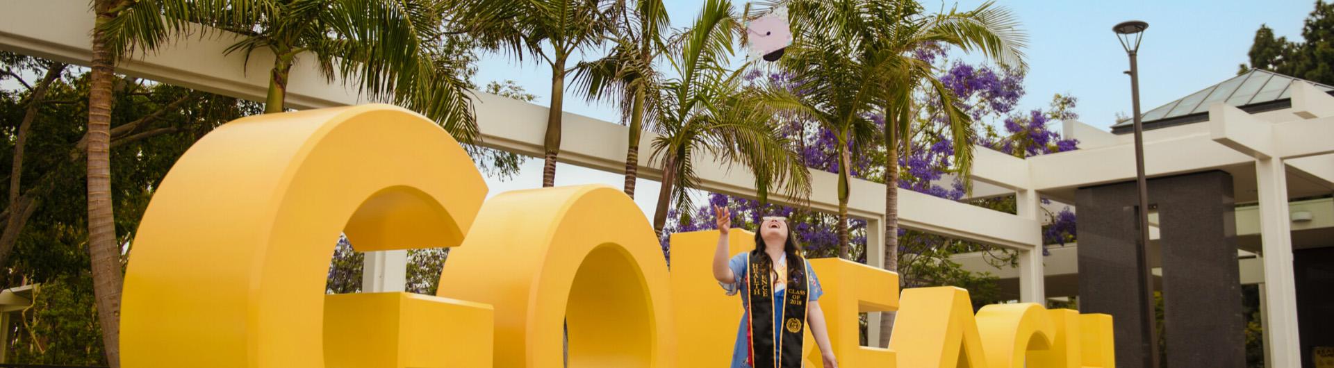 Graduate in front of Go Beach sign