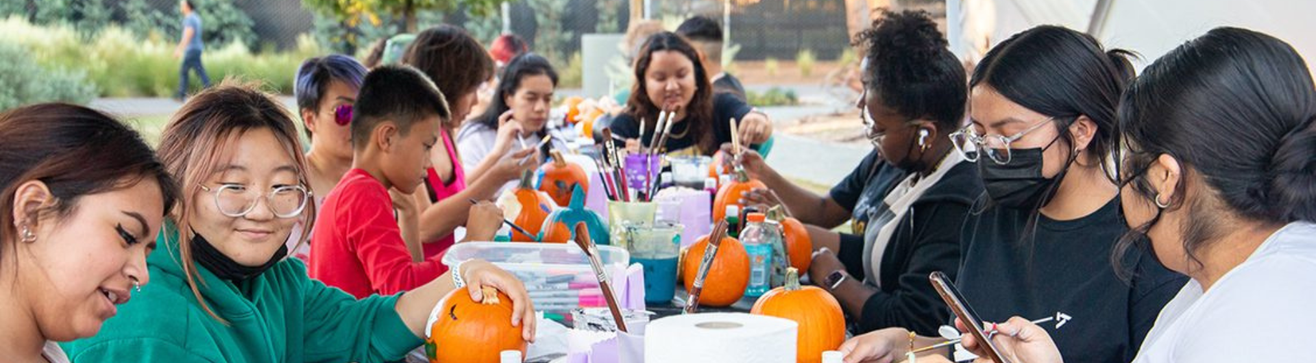 image by tatiana mata - a group of people works to paint pumpkins