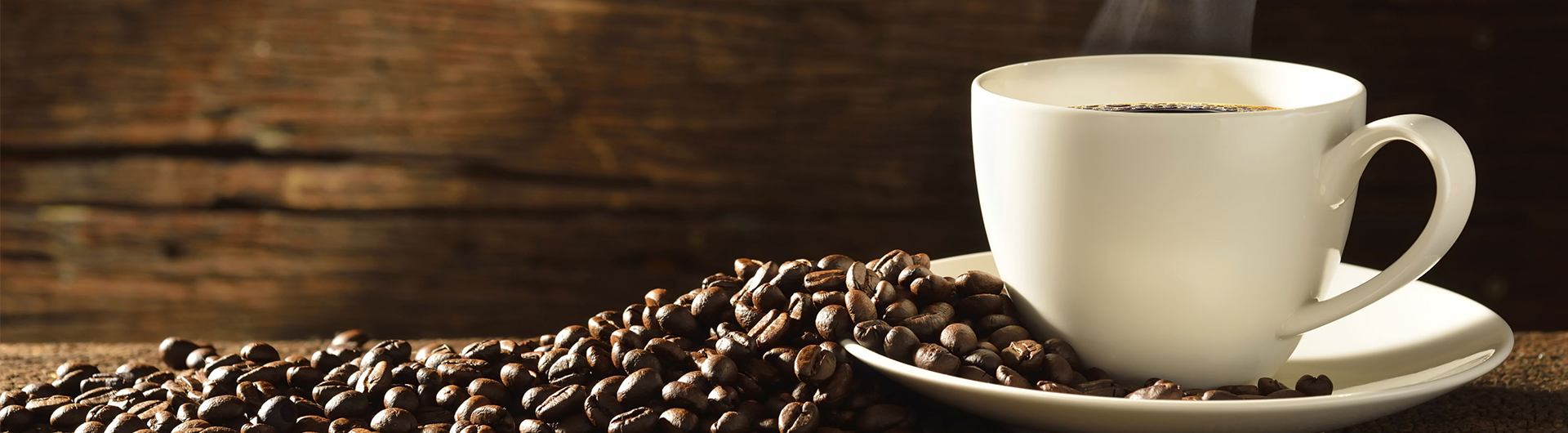 Cup of coffee on a saucer with coffee beans