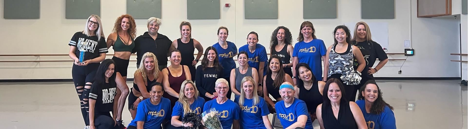 MPDW participants and teachers in a group pose within a dance studio.