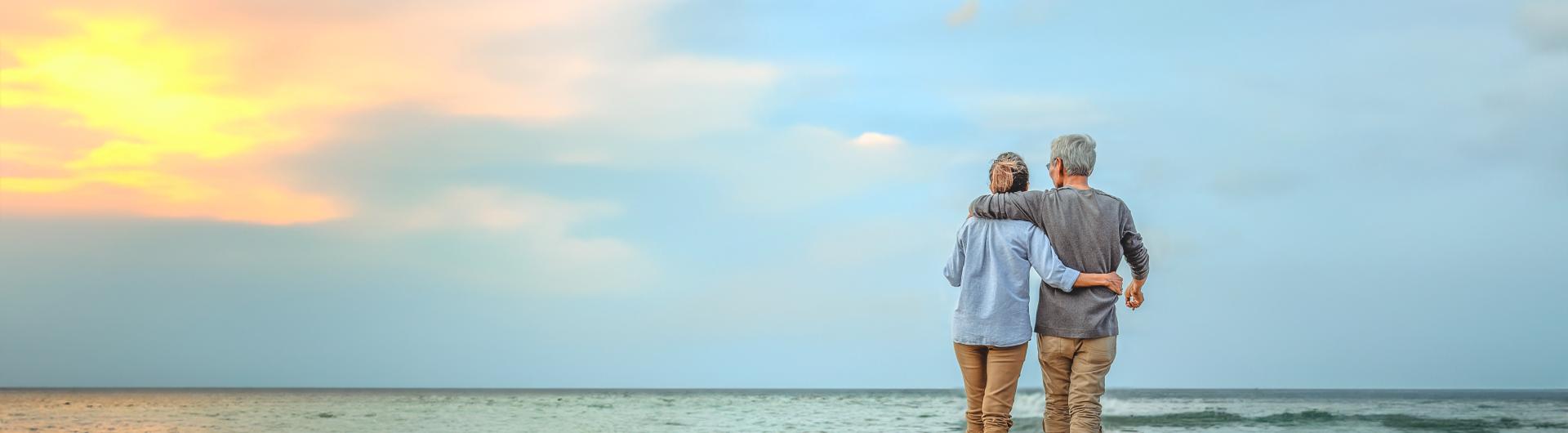 Older couple walking on the beach