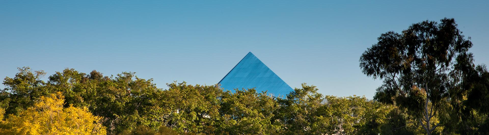 Pyramid behind a line of trees.