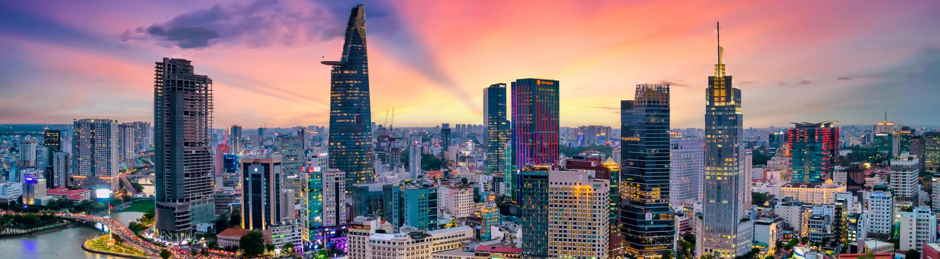 a lit up large asian city with bright lights at twilight