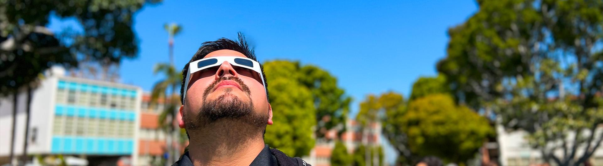CSULB staffer looks through eclipse glasses