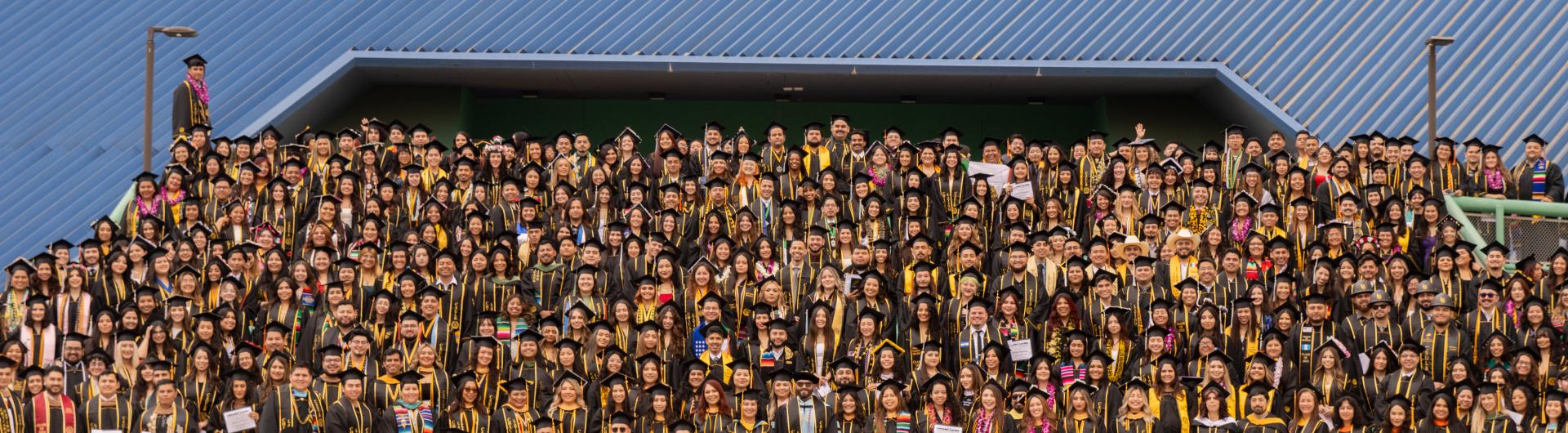 Latinx students posed for a group photo in front of the pyramid during the latinx cultural graduation