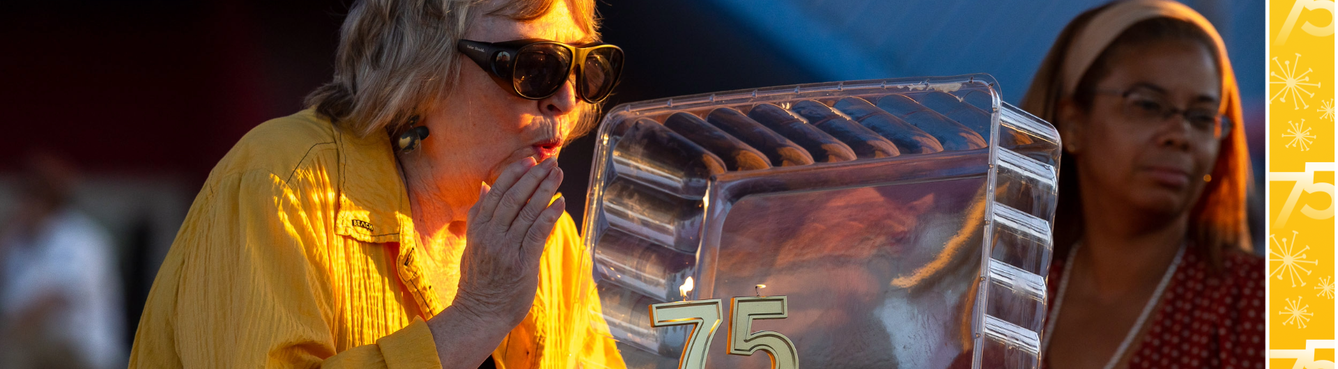 President Jane Close Conoley with cake topped by "75" candle for campus' anniversary
