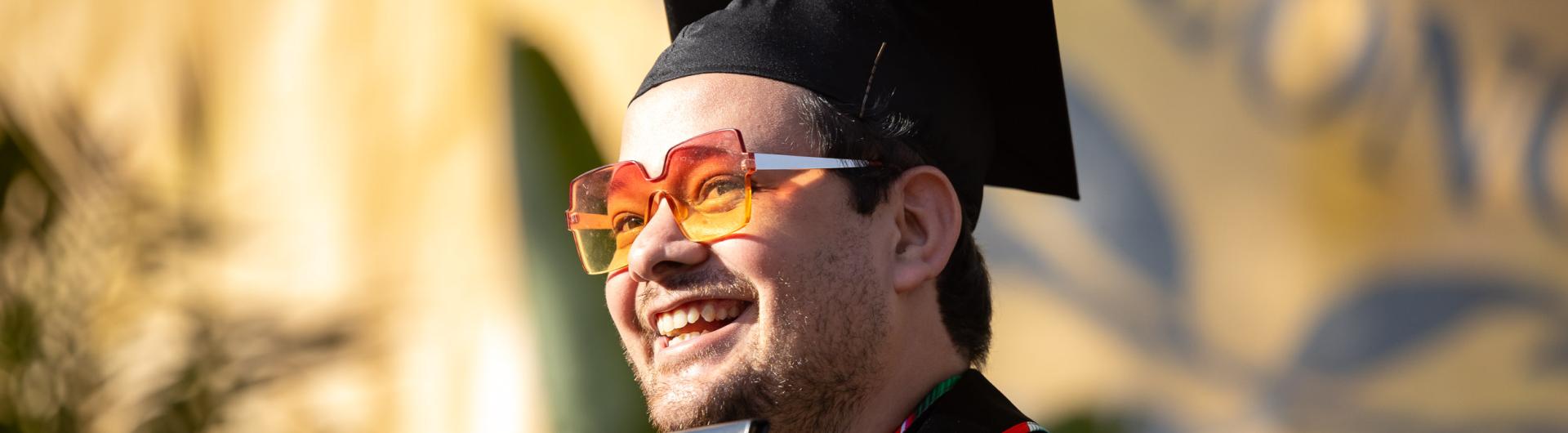 College of the Arts Graduate holding up their diploma