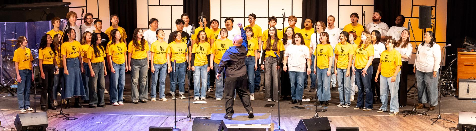 Members of the Community Gospel Choir Concert sing wearing yellow shirts